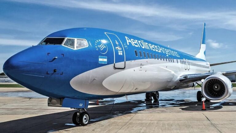 Avión de Aerolíneas Argentinas en vuelo con montañas de fondo, representando viajes y promociones.