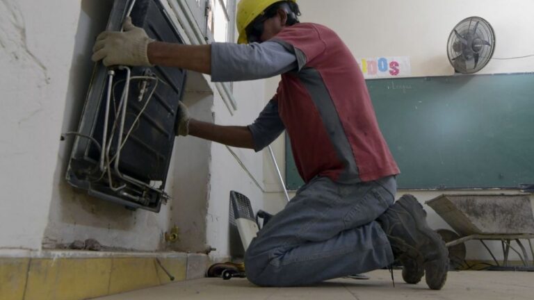 Trabajador revisando un calefactor en una escuela de Mendoza