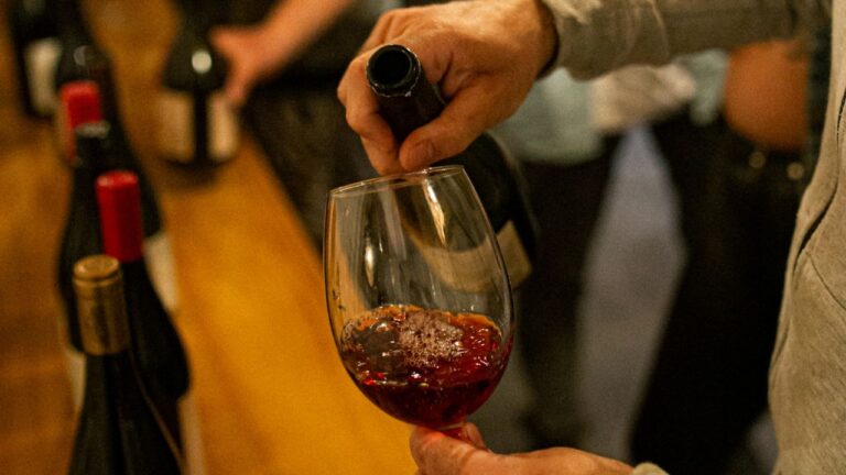 Personas disfrutando de una degustación de vinos en una vinoteca durante La Noche de las Vinotecas.