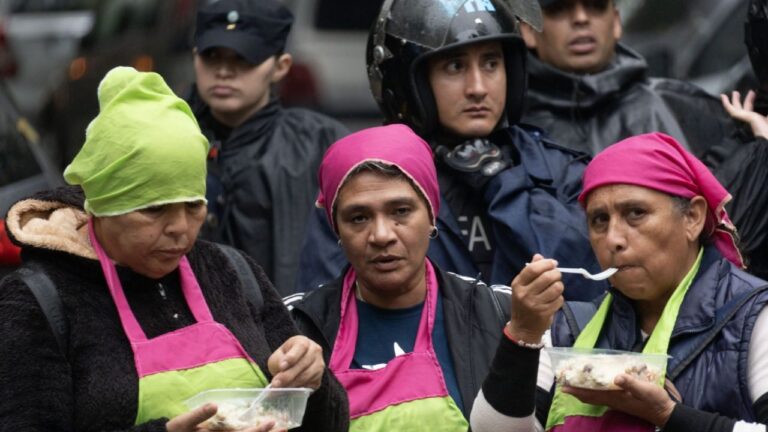 Personas participando de una olla popular durante una manifestación pacífica en una calle residencial.